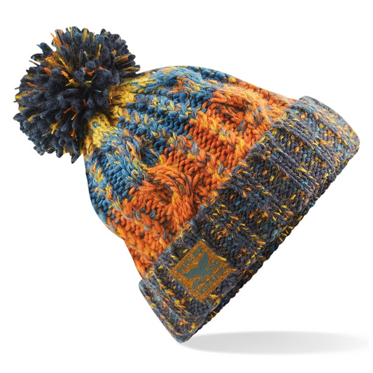 A fabulous knitted beanie hat with a fluffy pom pom on top. Knitted in shades of blues, oranges and yellows, the colours are reminiscent of the beach in the autumn sun. The wide fold up cuff makes this hat perfect for after a wild swim or cold water plunge.