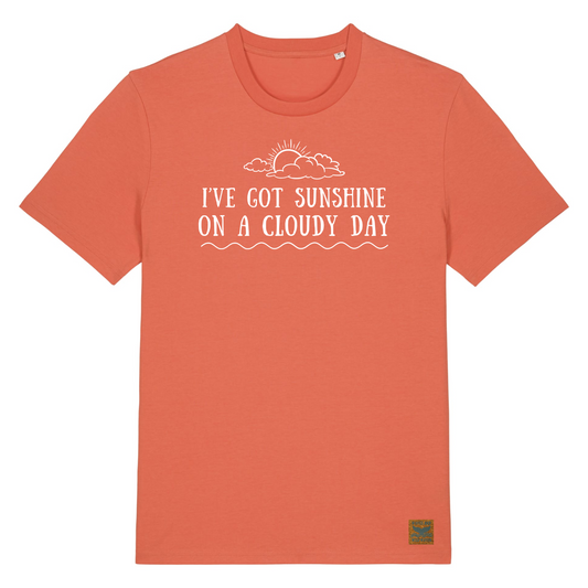 Vibrant orange organic cotton t-shirt with the text I've Got Sunshine On A Cloudy Day hand printed on the front in white vegan ink. There is also an image of a sun poking out from behind the clouds, making this a great tee for a feel-good vibe after a cold water swim on a less than perfect day.
