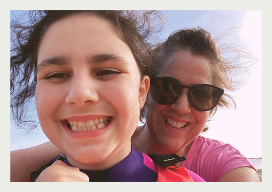 Claire from Waves and Wild Water warming up on the beach after a wild swim in the sea with her daughter.