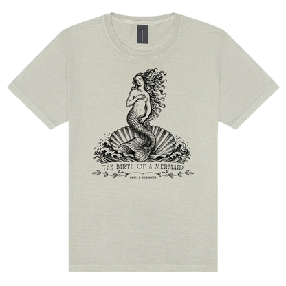 The Birth of a Mermaid washed cotton t-shirt in Seashell, featuring a black hand screen-printed mermaid on a shell inspired by Botticelli's The Birth of Venus. Exclusive to Waves & Wild Water and hand printed in South Wales.