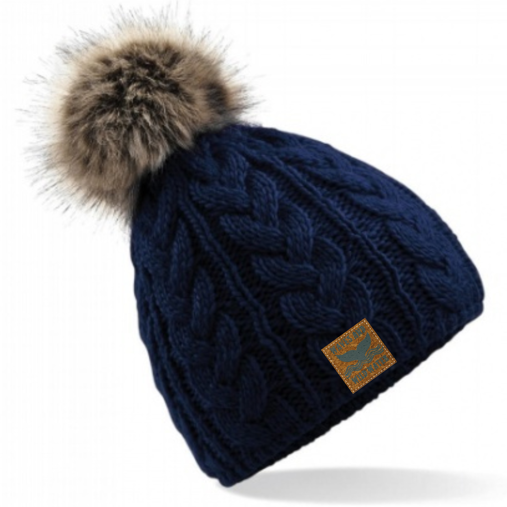 Waves and Wild Water gorgeous deep navy cable knitted beanie hat with fun furry pom pom. Perfect for keeping your head cosy after a sea dip, cold water plunge, or during a hike up the mountains!