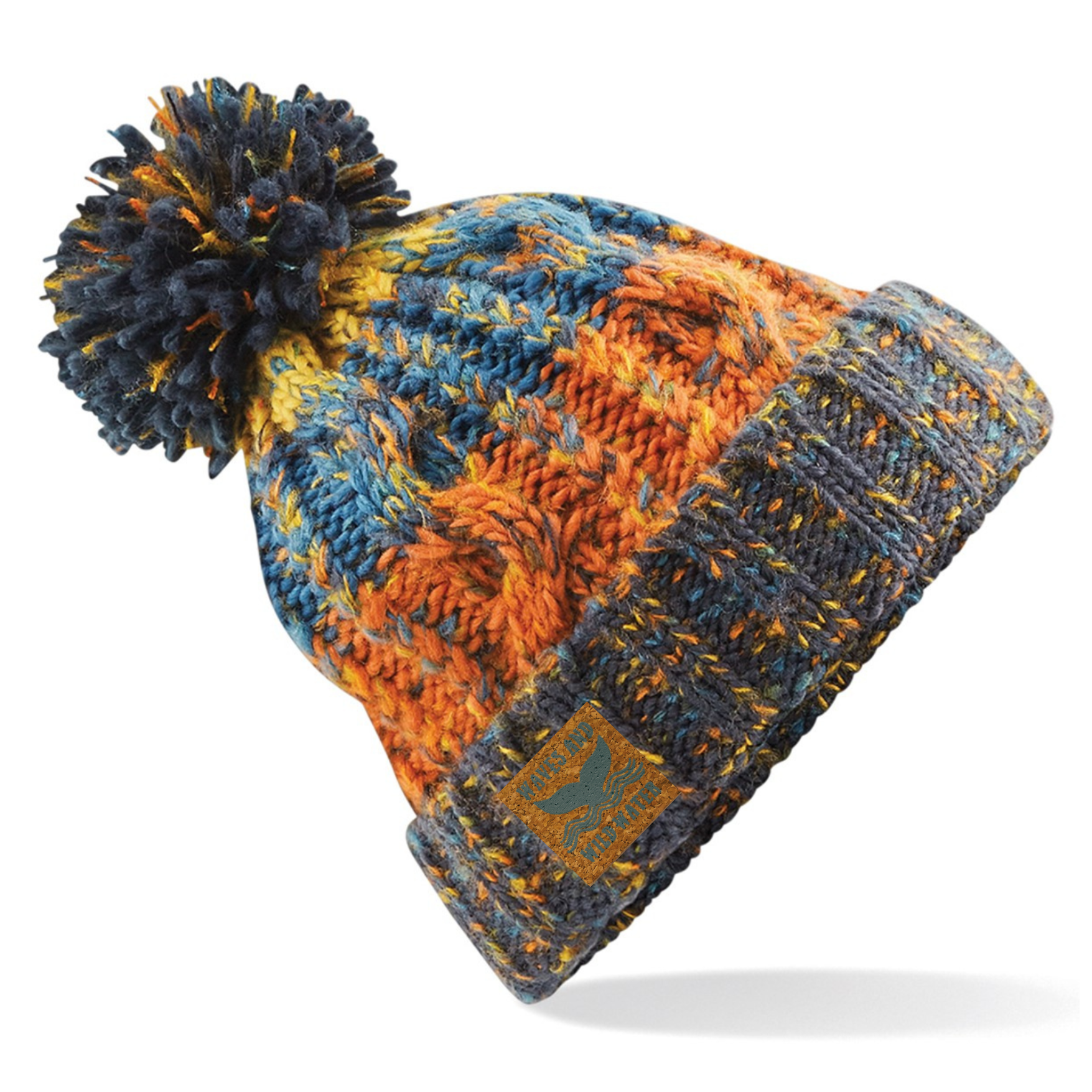 A fabulous knitted beanie hat with a fluffy pom pom on top. Knitted in shades of blues, oranges and yellows, the colours are reminiscent of the beach in the autumn sun. The wide fold up cuff makes this hat perfect for after a wild swim or cold water plunge. 