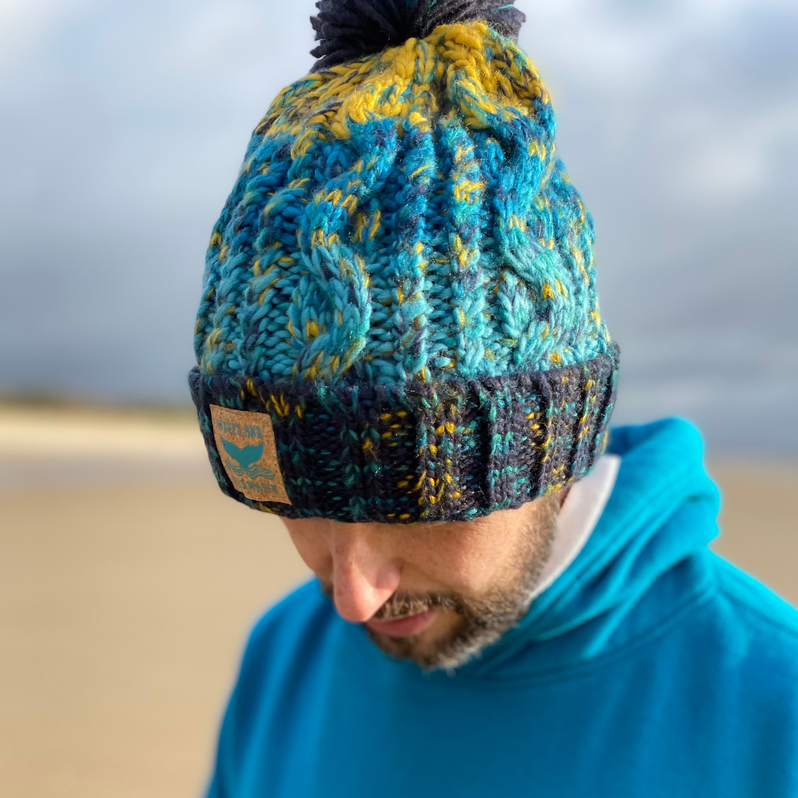 This fab knitted Ocean Depths beanie hat from Waves and Wild Water, showcases the stunning hues of blue found amongst the waves, with a little bit of sandy yellow to top it off!