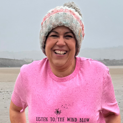 Wild swimmer and sea dipper Claire, wears her Seashell Pink knitted beanie hat and pink Listen To The Wind Blow t-shirt.