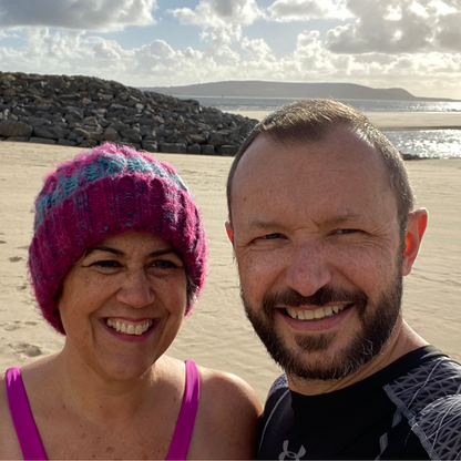 Waves and Wild Water owners, Claire and Glenn, get ready for a cold sea dip on an unusually sunny winter's day. Although she's only in skins, Claire isn't taking any risks with her head and is keeping it extra cosy under her Water Lily knitted beanie hat.