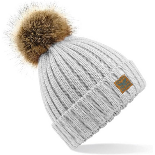 Our Frosty Morning heavy rib knitted beanie hat, adorned with a charming faux fur pom pom, is crafted from soft-spun yarn, and offers an incredibly comfortable feel. This gorgeous beanie is the perfect accessory for cold water swimmers, sea dippers, and those who cherish coastal living.