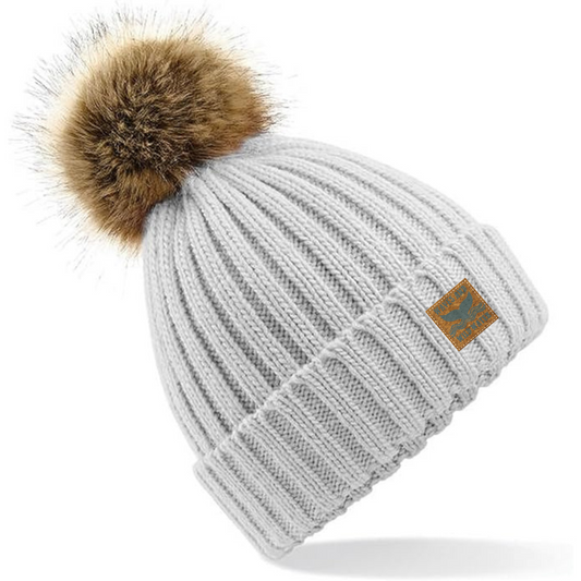 Our Grey Mist heavy rib knitted beanie hat, adorned with a charming faux fur pom pom, is crafted from soft-spun yarn, and offers an incredibly comfortable feel. This gorgeous beanie is the perfect accessory for cold water swimmers, sea dippers, and those who cherish coastal living.