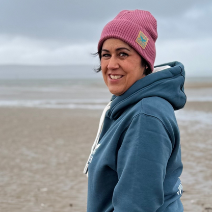 Waves and Wild Water owner Claire wears her Sunset Blush Fisherman Beanie on the beach at her home town of Burry Port, Wales.