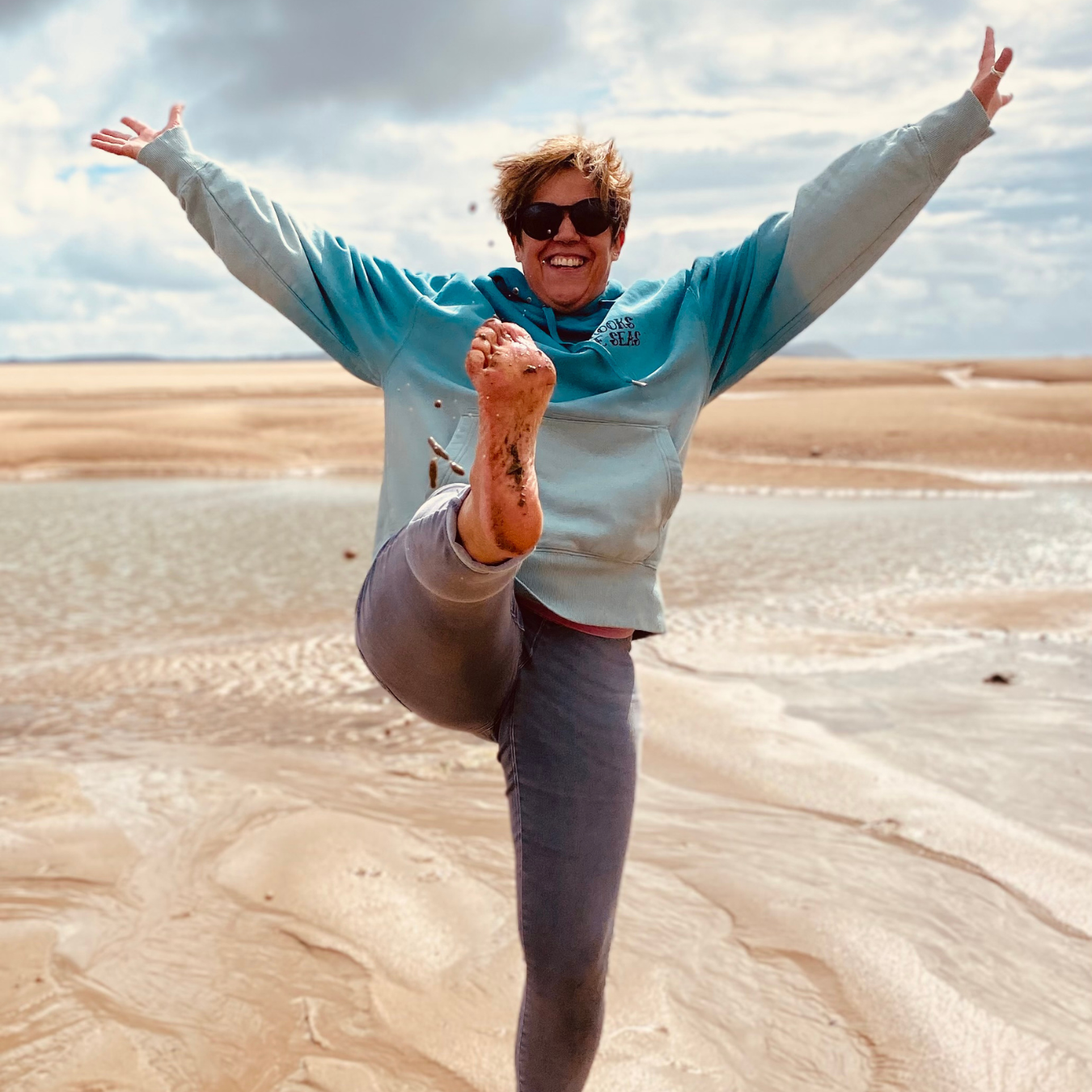 Emphasising the basis for all the Waves and Wild Water designs, owner Claire has fun on the beach after a bracing did in the sea. She's  wearing her Babbling Brooks hoodie to make sure she stays warm whilst dancing barefoot on the sand.