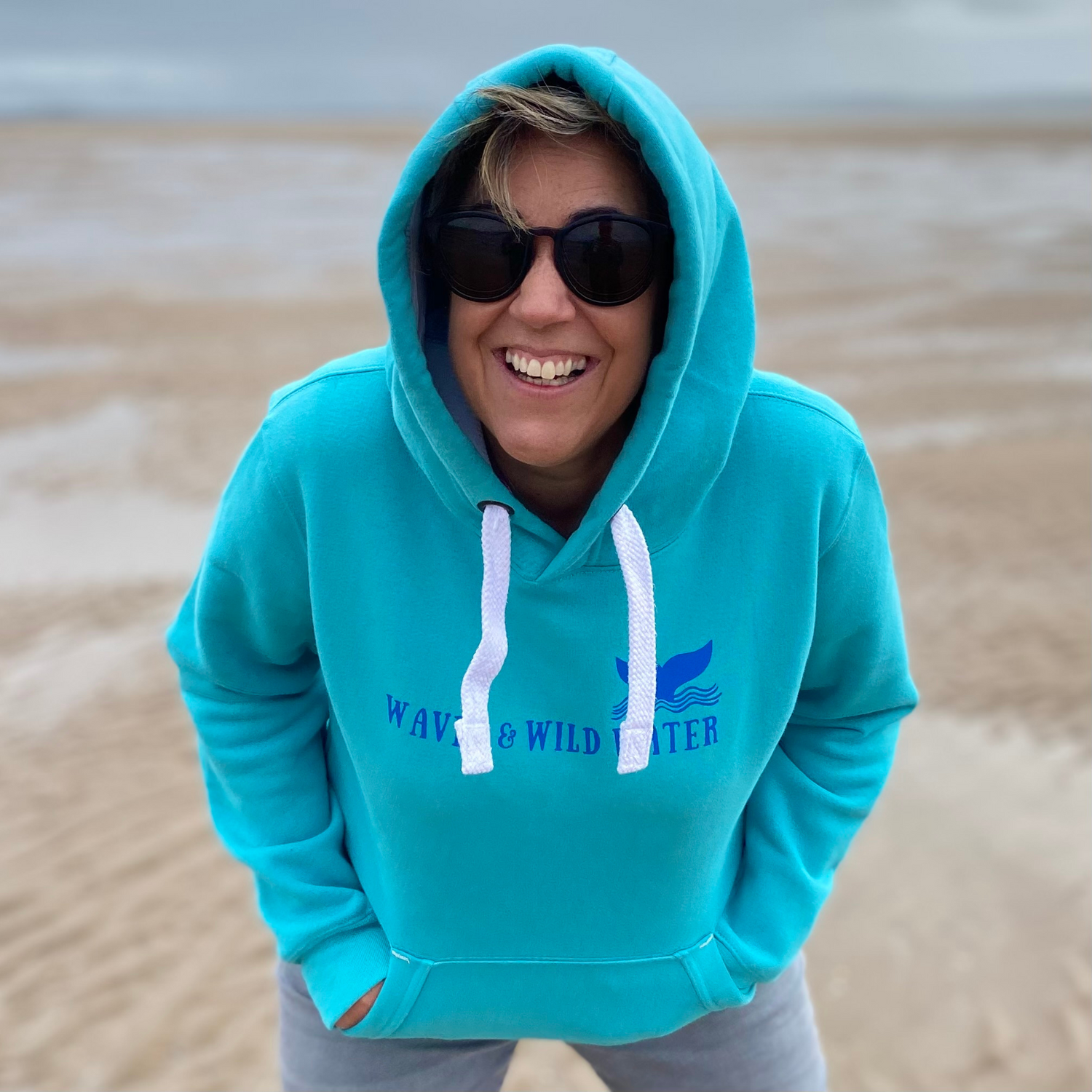 Waves and Wild Water owner Claire, wears her Lagoon hoodie n the beach in South Wales. She loves her hoodie and so do lots of other wild swimmers and sea dippers.