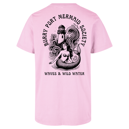 Pale pink cotton t-shirt featuring an illustrated mermaid with flowing hair in front of Burry Port lighthouse, with bold black water-based text.