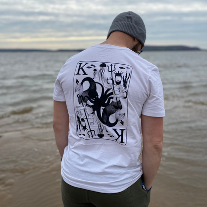 Waves and Wild Water owner Glenn, wears his King Of Seas t-shirt on a grey day at the beach, proving that not even the weather can overpower the might of the ruler of the seas! Printed on natural recycled organic cotton tees, our exclusive design depicts the king of merpeople in his domain under the sea.