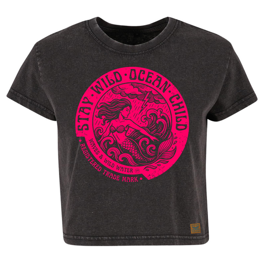Vintage black cropped sustainable cotton t-shirt with bright magenta ink design of a mermaid in stormy seas, framed by Stay Wild Ocean Child text.
