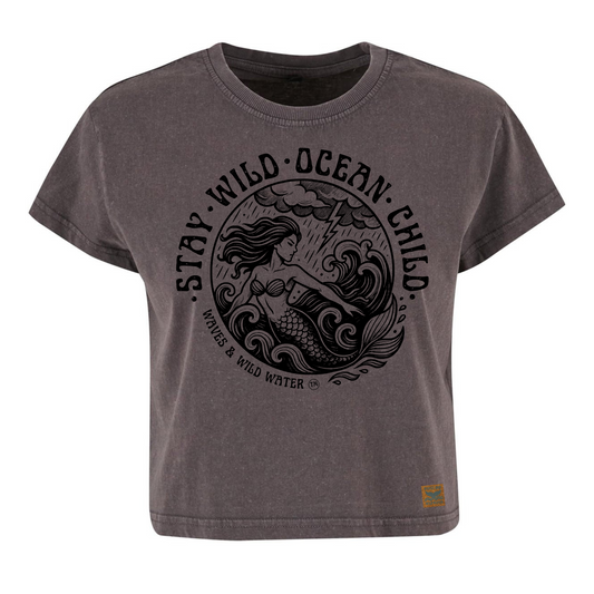 Vintage grey cropped sustainable cotton t-shirt with black ink design of a mermaid in stormy seas, framed by Stay Wild Ocean Child text. Exclusively from Waves and Wild Water.