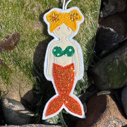 Handmade mermaid hanging decoration with orange glitter tail, perfect as a coastal gift or keepsake for sea lovers and wild swimmers.