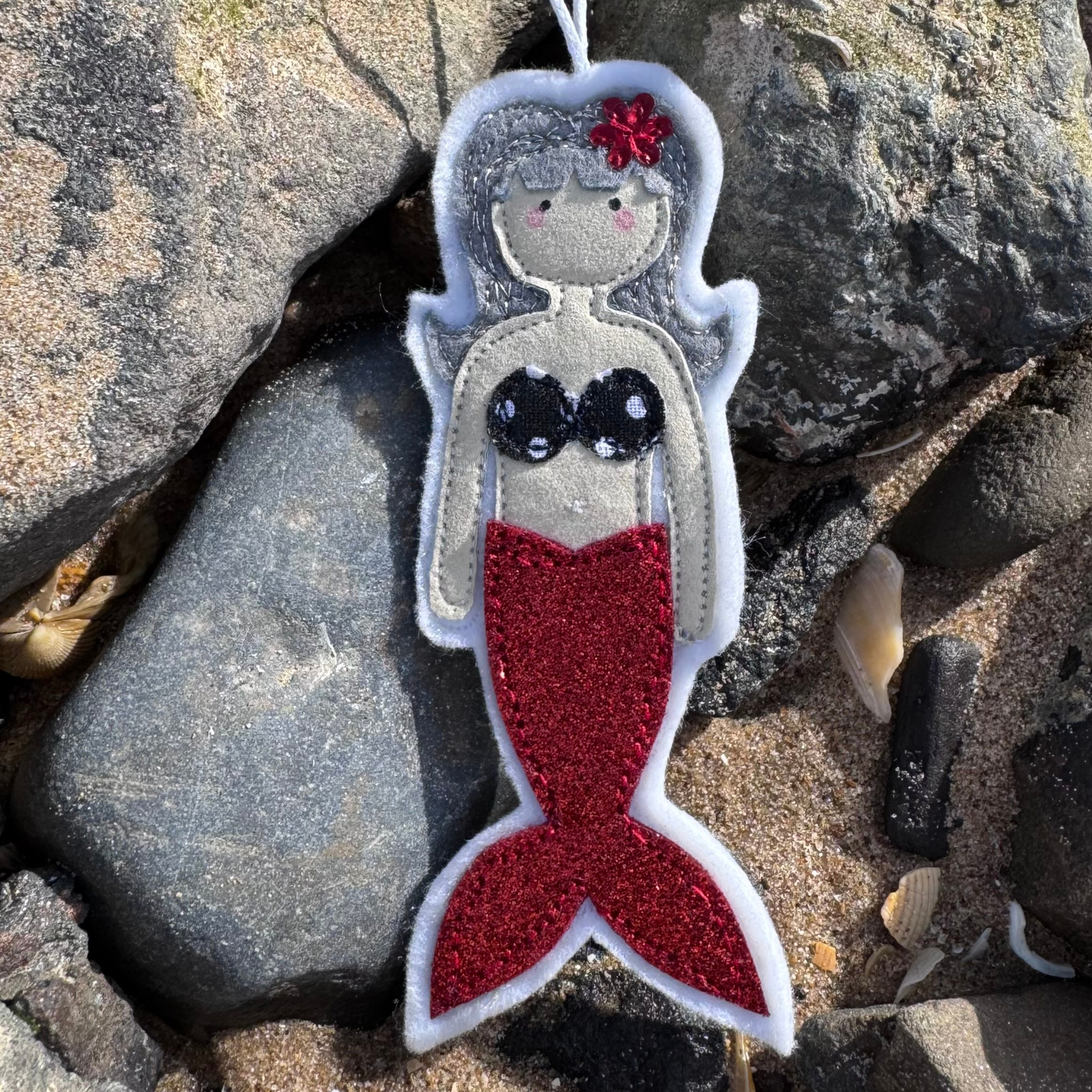 Handmade mermaid hanging decoration with red glitter tail, a thoughtful coastal gift for sea lovers and wild swimmers.